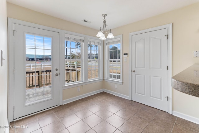 unfurnished dining area with tile patterned flooring and a chandelier