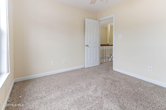 spare room featuring ceiling fan and carpet