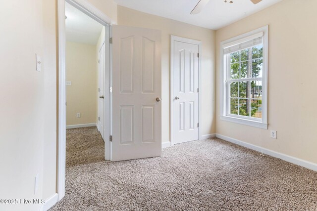 unfurnished bedroom with ceiling fan, carpet flooring, and a closet