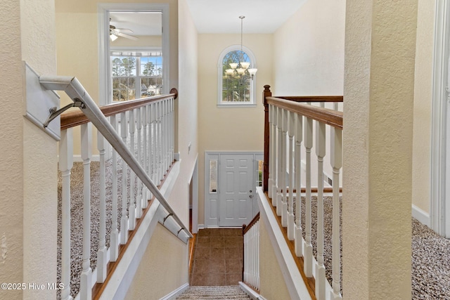 stairs with tile patterned flooring and a chandelier