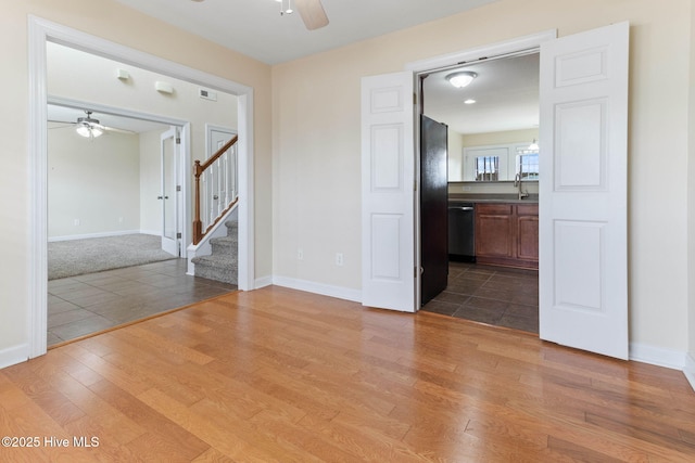 spare room with dark wood-type flooring, ceiling fan, and sink