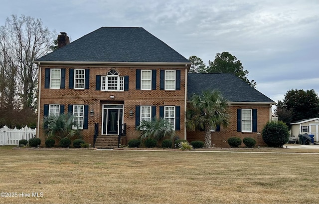 colonial-style house featuring a front lawn