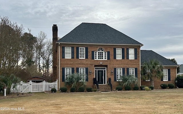 colonial inspired home featuring a front lawn