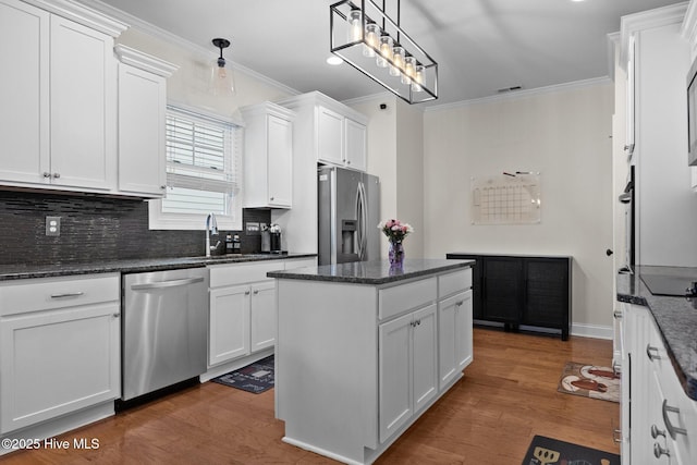 kitchen with white cabinets, pendant lighting, stainless steel appliances, and dark hardwood / wood-style floors