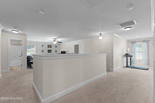 hall featuring light carpet, plenty of natural light, and ornamental molding