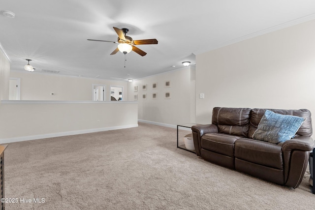 living room with ceiling fan, ornamental molding, and light carpet