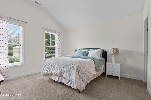 bedroom featuring light colored carpet and lofted ceiling