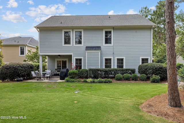 back of property with a lawn, a patio area, and ceiling fan