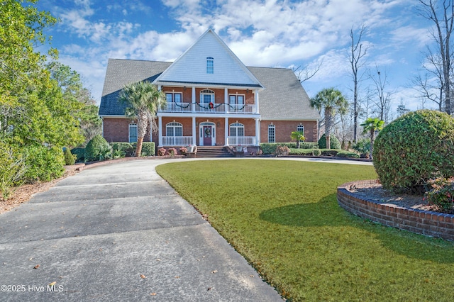 view of front of property featuring a front lawn, a porch, and a balcony