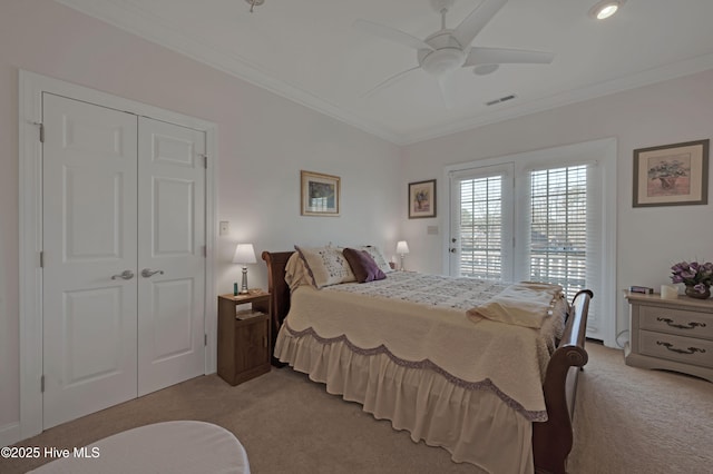 bedroom with ceiling fan, a closet, light colored carpet, and crown molding