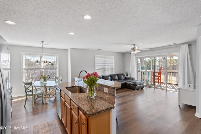 3350 Club Villas Dr Unit 205, Southport, NC 28461 - kitchen featuring a sink, a textured ceiling, brown cabinets, dark wood-type flooring, and plenty of natural light