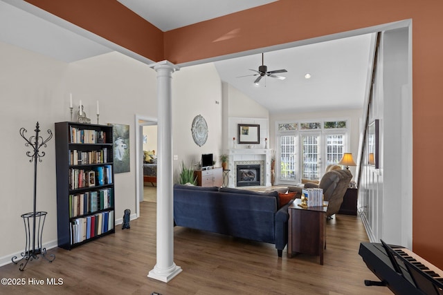 living room with ceiling fan, dark hardwood / wood-style floors, high vaulted ceiling, and ornate columns