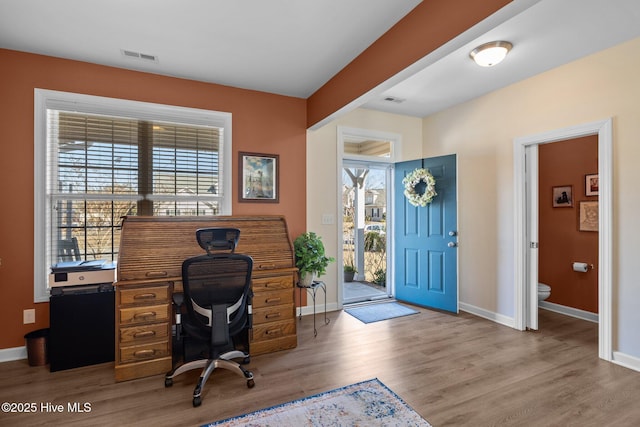 home office with light hardwood / wood-style flooring