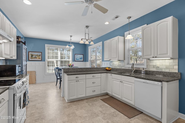 kitchen featuring sink, white appliances, white cabinetry, and pendant lighting