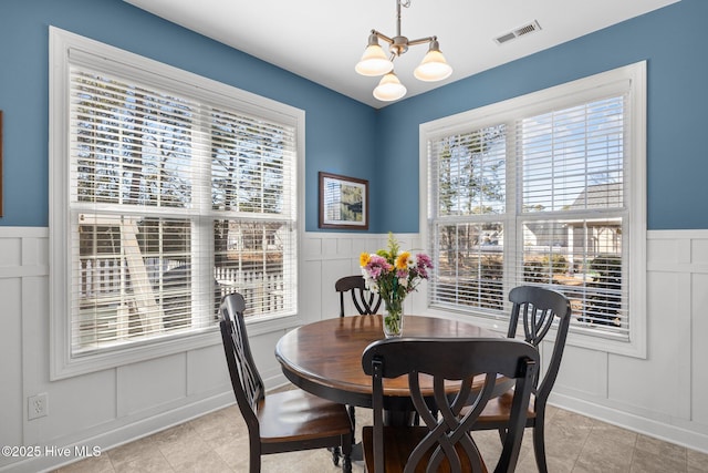 tiled dining room featuring an inviting chandelier