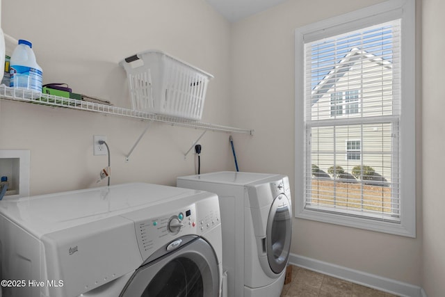 clothes washing area with washer and clothes dryer and a healthy amount of sunlight