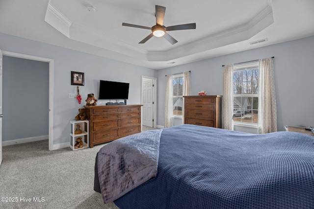 carpeted bedroom featuring a tray ceiling, ceiling fan, and ornamental molding