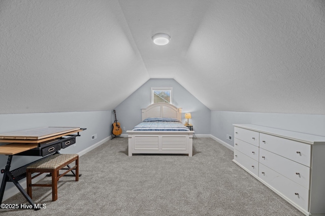 carpeted bedroom featuring a textured ceiling and vaulted ceiling