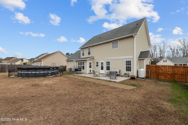 rear view of property featuring a patio area and a covered pool