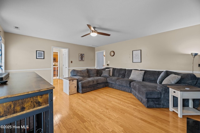 living room featuring light hardwood / wood-style flooring and ceiling fan