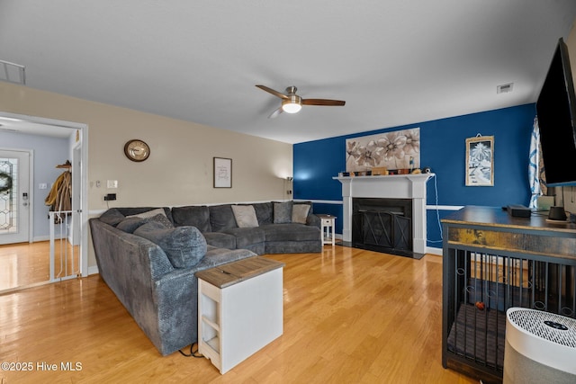 living room with hardwood / wood-style floors, a wealth of natural light, and ceiling fan