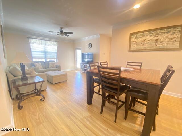 dining area with ceiling fan, ornamental molding, and light hardwood / wood-style flooring