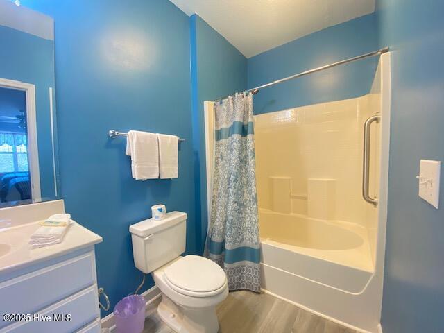 full bathroom with vanity, wood-type flooring, shower / bath combo, and toilet