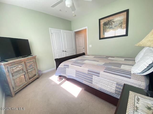 bedroom featuring a closet, ceiling fan, and light colored carpet