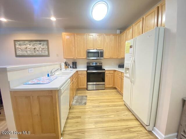 kitchen featuring kitchen peninsula, light brown cabinetry, stainless steel appliances, sink, and light hardwood / wood-style flooring