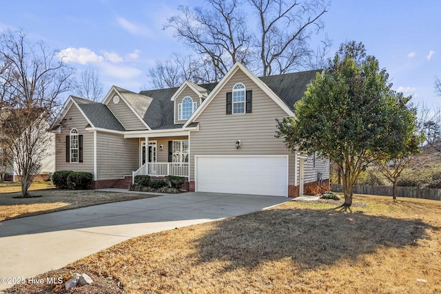 view of front of home with covered porch, a garage, and a front yard