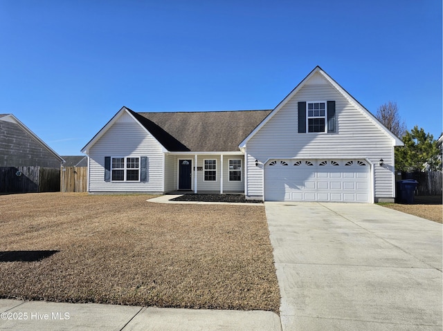 traditional-style house with an attached garage, fence, a front lawn, and concrete driveway