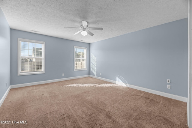 spare room with carpet, a textured ceiling, ceiling fan, and a healthy amount of sunlight