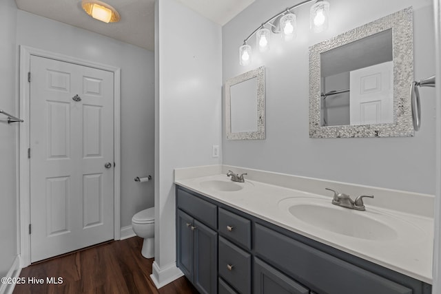 bathroom featuring hardwood / wood-style flooring, vanity, toilet, and a textured ceiling