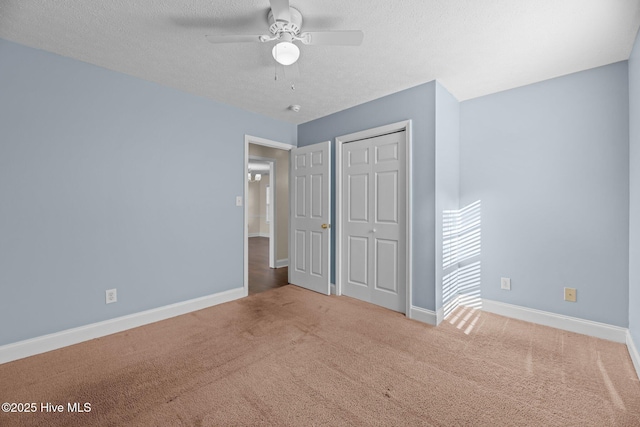 unfurnished bedroom featuring carpet flooring, ceiling fan, a textured ceiling, and a closet