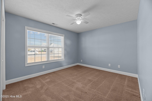 carpeted spare room featuring ceiling fan and a textured ceiling