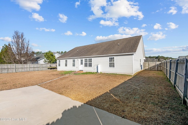 rear view of property featuring a lawn and a patio