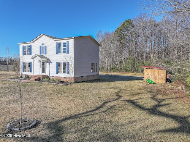 view of front of house featuring a storage unit and a front yard