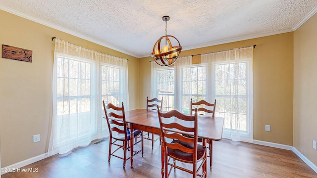 dining area with hardwood / wood-style flooring, crown molding, a textured ceiling, and an inviting chandelier