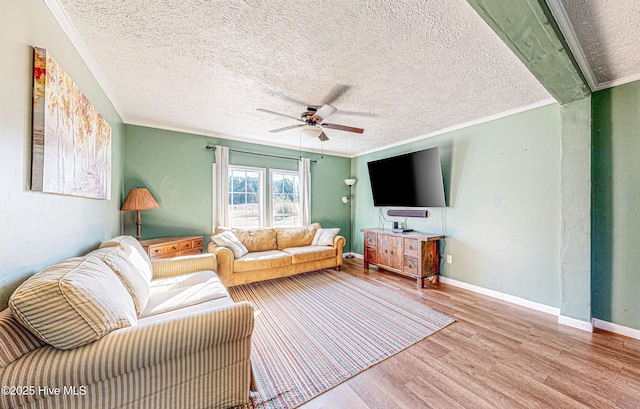 living room featuring crown molding, ceiling fan, wood-type flooring, and a textured ceiling