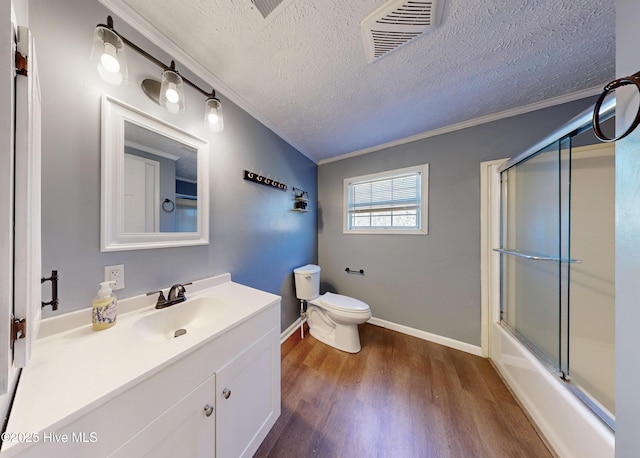 full bathroom with enclosed tub / shower combo, hardwood / wood-style floors, a textured ceiling, toilet, and vanity