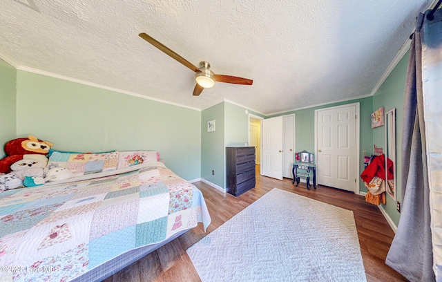 bedroom with ceiling fan, ornamental molding, a textured ceiling, and light hardwood / wood-style flooring