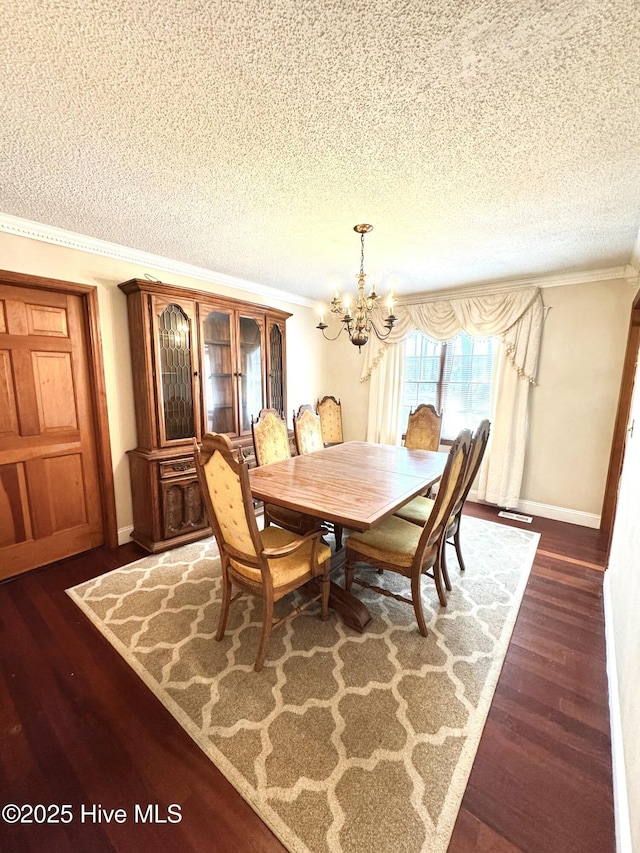 dining area with an inviting chandelier, ornamental molding, dark hardwood / wood-style flooring, and a textured ceiling