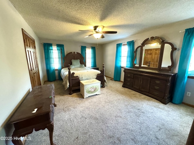 carpeted bedroom featuring ceiling fan and a textured ceiling