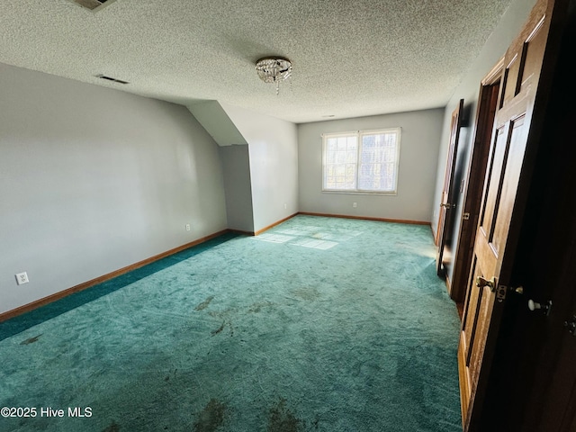 bonus room with a textured ceiling and carpet flooring