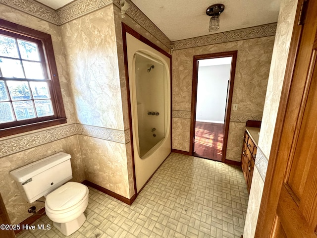 full bathroom with vanity, a textured ceiling, shower / bathtub combination, and toilet