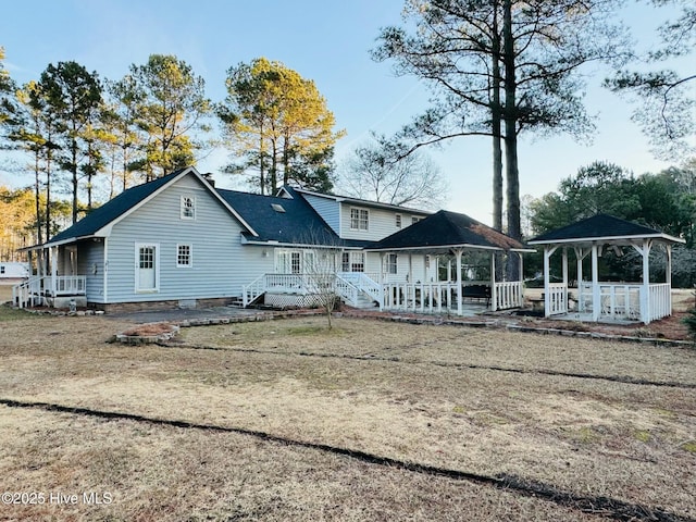 rear view of property with a gazebo and a yard