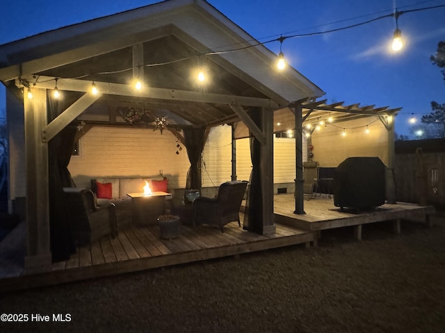 deck at night with a gazebo and a fire pit