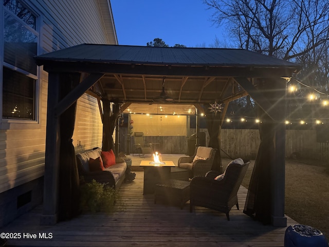 deck featuring a gazebo and an outdoor living space with a fire pit