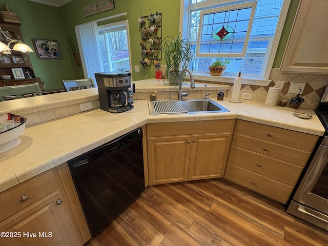 kitchen with wood-type flooring, light brown cabinetry, sink, black dishwasher, and tasteful backsplash