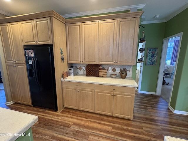 kitchen featuring black fridge with ice dispenser, dark hardwood / wood-style flooring, tasteful backsplash, and crown molding